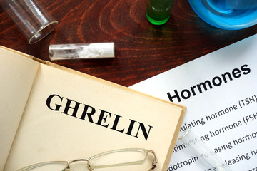 Hormone ghrelin  written on book. Test tubes and hormones list.