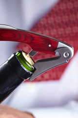 man opening a bottle of wine
