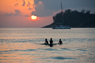 Boys on boards in sunset