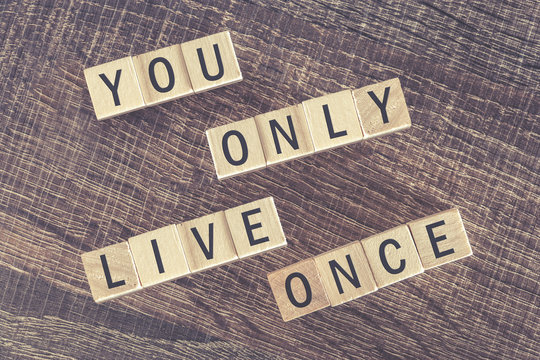 You Only Live Once (YOLO) message formed with wooden blocks. Cross processed image with shallow depth of field