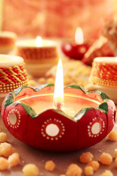 Diwali, celebration of lights.Glowing Red Diya arranged in a row along with some spread of north Indian Sweet Bhoondhi.