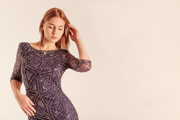 Profile portrait of an elegant  girl wearing a backless dress. 