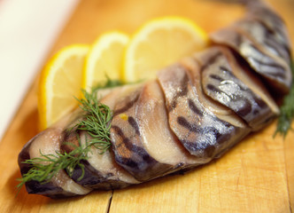 A composition with mackerel fish on wooden plate isolated on white background