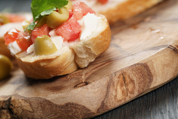 homemade crostini with tomato, mozzarella and olives