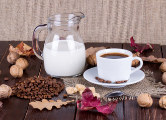 Coffee cup, cream, coffee grains and cane sugar