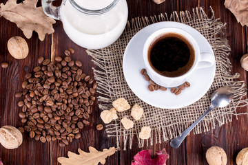 Coffee cup, cream, coffee grains and cane sugar