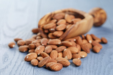 roasted almonds on blue wooden table with scoop