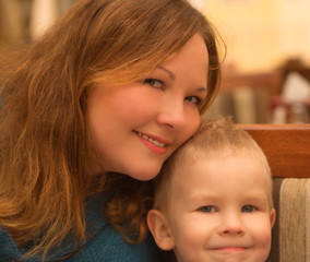 Little cute boy and his mother in a cafe