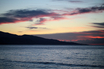 Fototapeta premium Mountain silhouette in sea after sunset