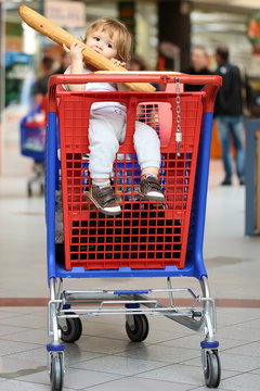 Baby Biting French Bread In Shopping Trolley