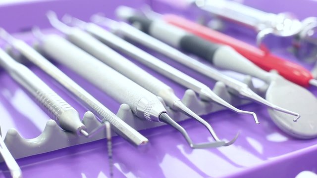 Different dental instruments on a purple tray / camera aproaching / close-up