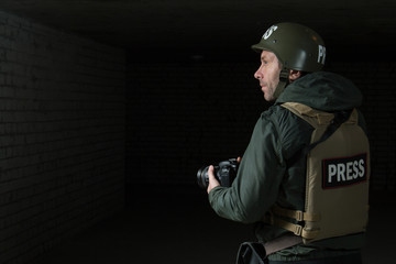 Photojournalist in a helmet and flak jacket wore protective equipment for shooting in hot spot