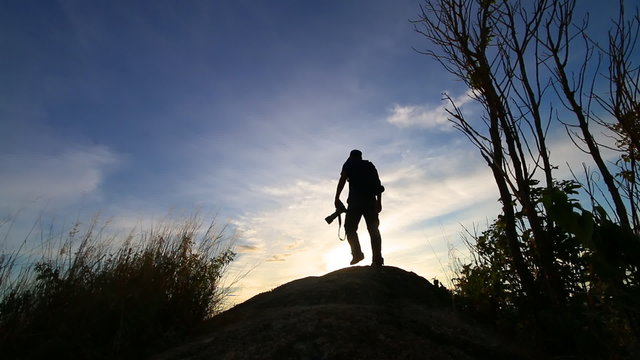 Silhouette of Photographer standing on the mountain in sunset time
