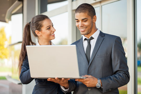 Business man and woman with laptop  talking,outdoor
