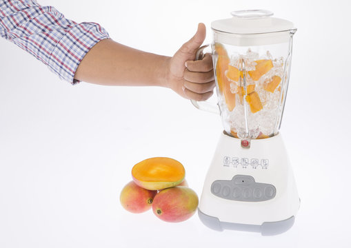 Licuadora, con fruta y jugo sobre fondo blanco.