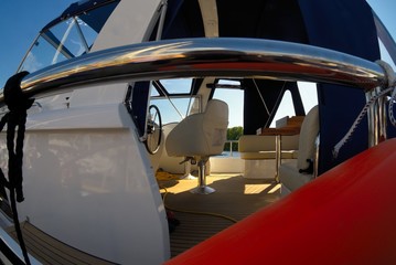 Fototapeta na wymiar Steering wheel, captain's chair and navigation instruments on boat cabin. Fisheye view
