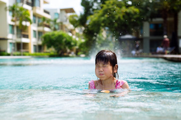 Naklejka premium Little girl swim in the pool