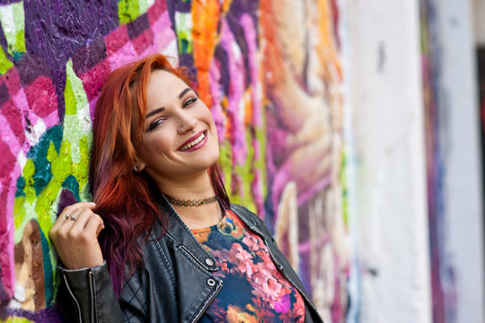 modern urban girl in front of graffiti wall