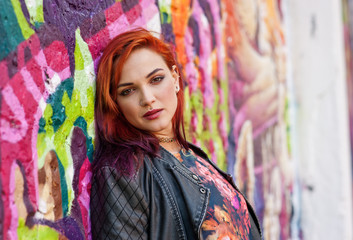 modern urban girl in front of graffiti wall