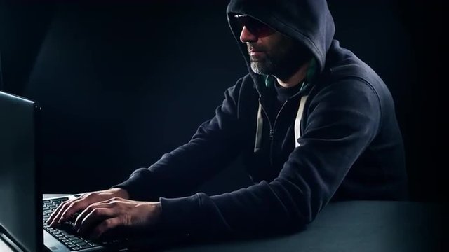 Futuristic cyber crime, hacker man typing on laptop computer 4K