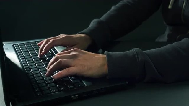 Man typing on laptop keyboard at night 4K