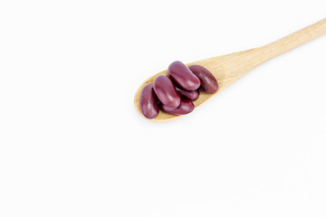 Red kidney beans on a wooden spoon isolate on white