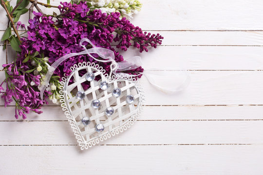  Decorative heart  and lilac flowers on wooden background.