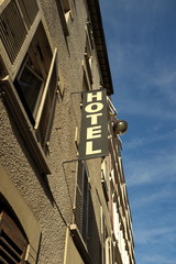 Fototapeta na wymiar Hotel, enseigne verticale, batiment ancien, ciel bleu.