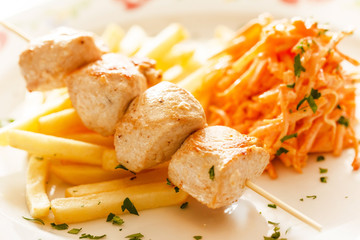 Chicken skewers with french fries
