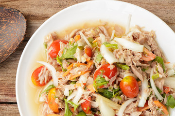Spicy Tuna Salad onion and tomatoes in plate put on wooden background , Thailand cuisine.