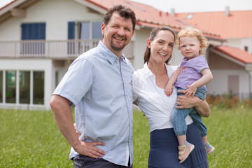 Happy family having fun in front of house