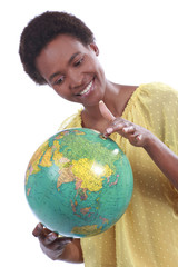 Fototapeta premium Lächelnde afrikanische Frau hält eine Weltkugel
