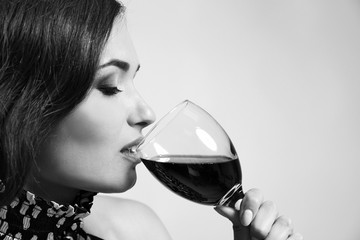 Portrait of beautiful woman drinking wine, black and white retro stylization