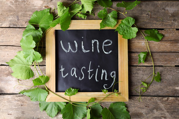 Old square chalk scripted frame with vine on wooden background