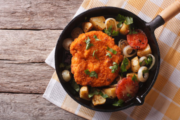 German Weiner schnitzel with vegetables in a pan. horizontal top view
