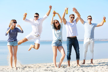 Obraz premium Young people with beer on the riverside