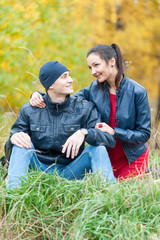 Naklejka na ściany i meble Young romantic couple sits on plaid. Autumn picnic