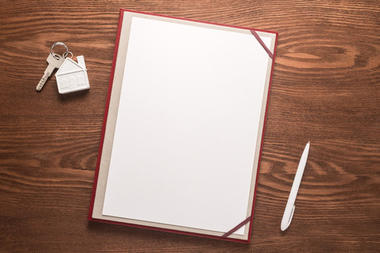 Blank Paper, Pen And Key On Wooden Desk 
