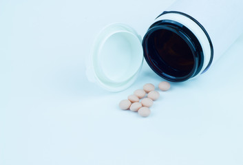 Pink pills and white pill bottle on the white background (color