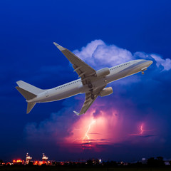 Obraz premium Commercial airplane flying with clouds and thunderstorm backgrou