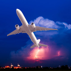 Commercial airplane flying with clouds and thunderstorm backgrou