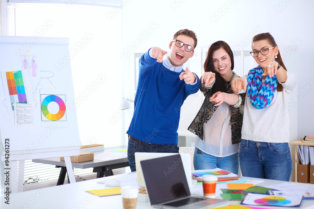 Wall mural young business people standing at office near desk and showing