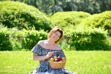 adult woman with a basket of fruit in the park