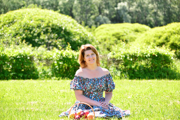 adult woman with a basket of fruit in the park