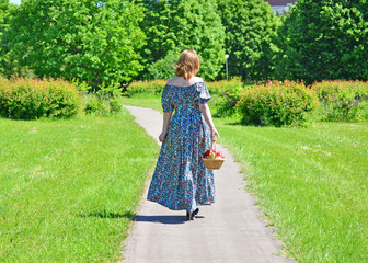 adult woman with a basket of fruit in the park