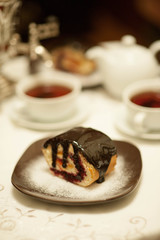 On the white tablecloth is a samovar, a teapot, a cup of tea and sweets, biscuits, rolls, tea,