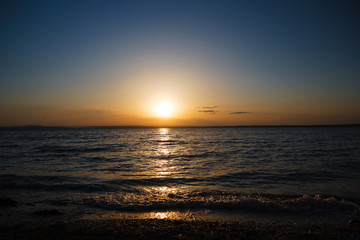 Fototapeta na wymiar Sunset over the sea, a beautiful evening ocean, water nature, wildlife of the sea, the horizon, a romantic trip, beach night, sea waves, coastal landscape.