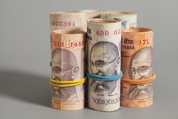 Rolls of Indian rupees isolated on gray background