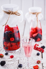 Berry homemade liqueur fresh raspberries,blueberries,currants and strawberries.selective focus