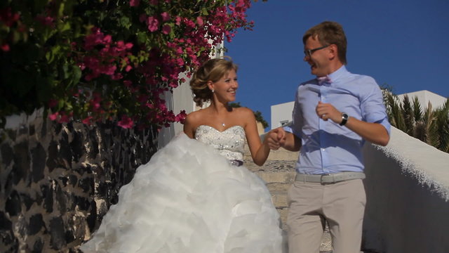 happy bride and groom smiling and walkinng in island Santorini